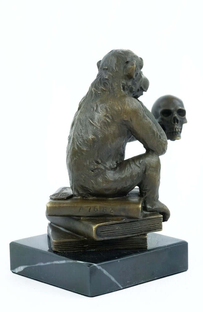 Bronze sculpture of a thinking monkey on books, holding a skull, mounted on a marble base, 14x12 cm.