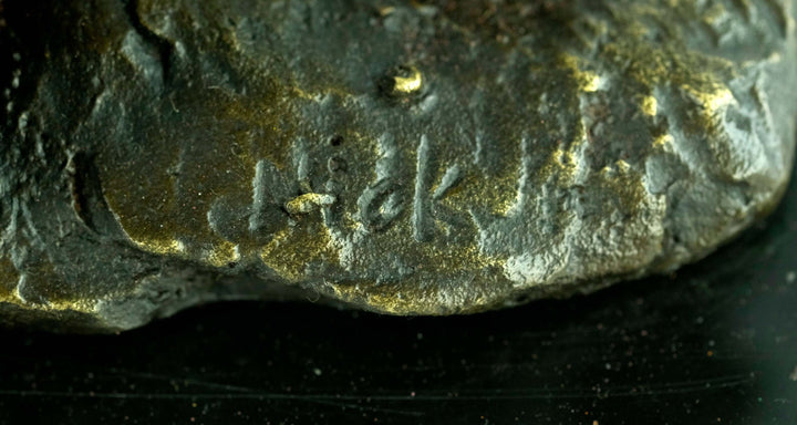 Signature detail of a bronze pirate sculpture by Nick, showcasing intricate craftsmanship.
