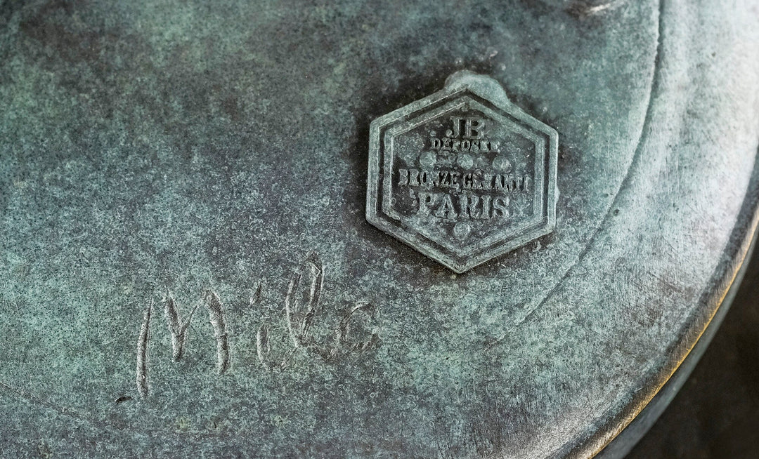 Close-up of a bronze sculpture stamp and signature 'Milo', showcasing quality craftsmanship and authenticity.