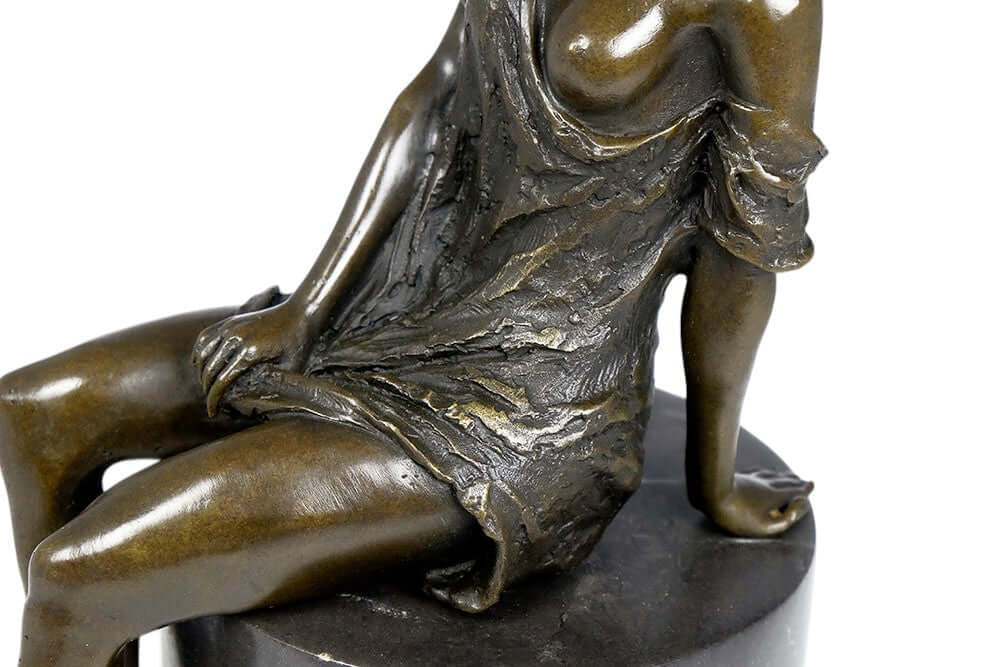 Bronze sculpture of a sitting female in a flimsy dress, elegantly detailed, mounted on a round marble base.