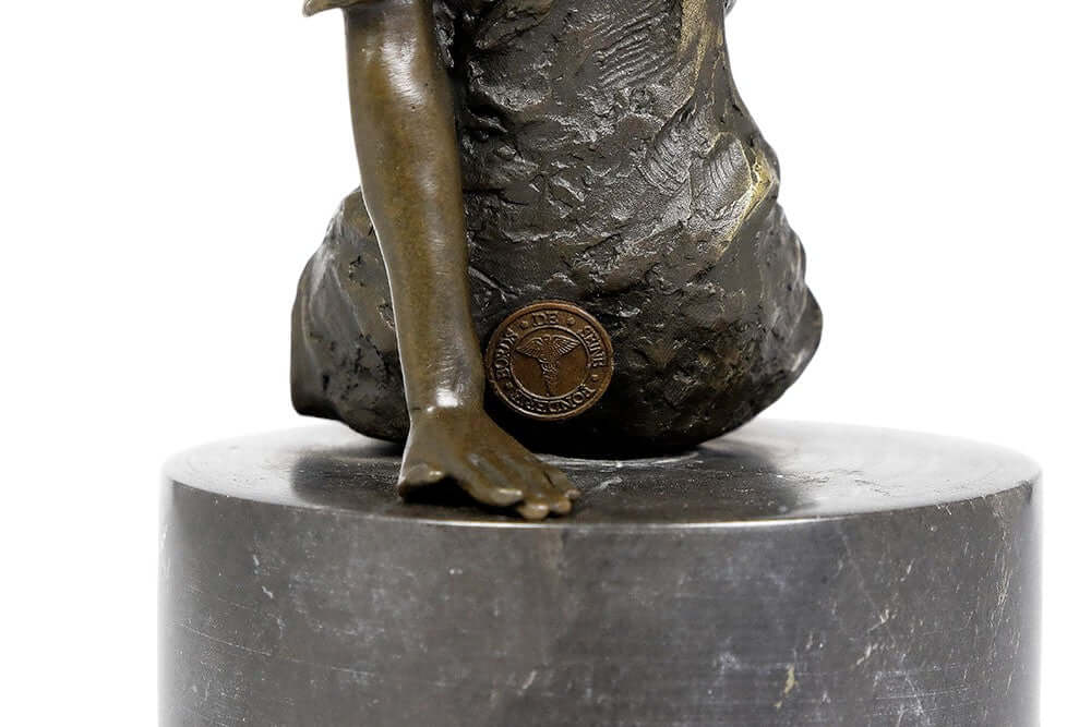 Close-up of a bronze sculpture of a sitting female figure, showcasing detail and craftsmanship on marble base.