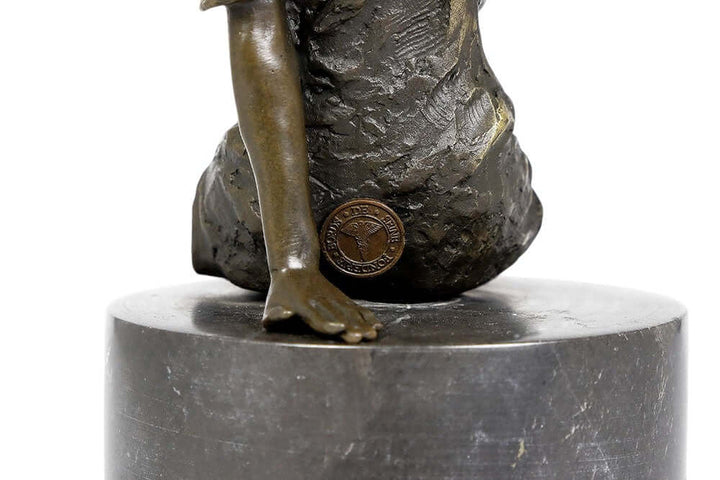 Close-up of a bronze sculpture of a sitting female figure, showcasing detail and craftsmanship on marble base.