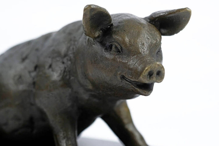 Bronze sculpture of a smiling sitting pig, crafted with quality detail, showcasing a delightful farm animal design.