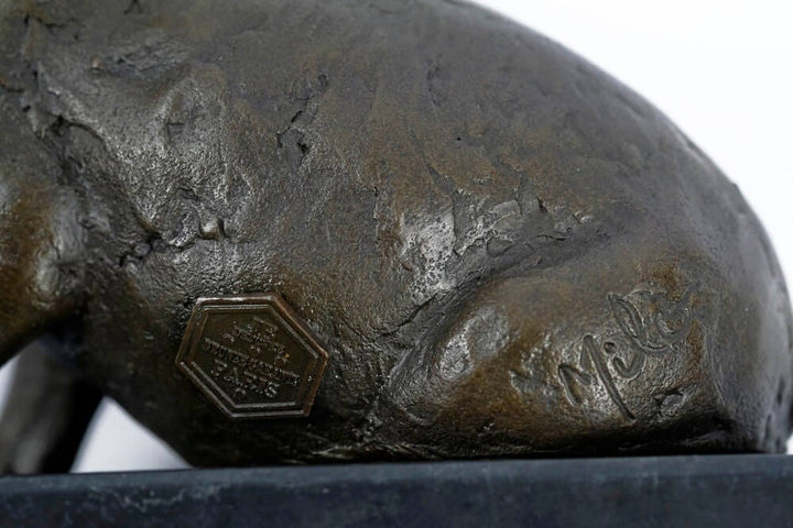 Close-up of the signature and foundry stamp on a bronze sculpture of a sitting pig, by artist Milo.