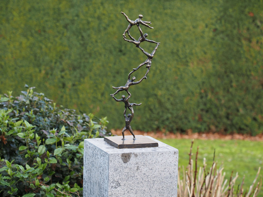 Modern bronze sculpture 'Together to the Top' showcasing six figures symbolizing teamwork and ambition.