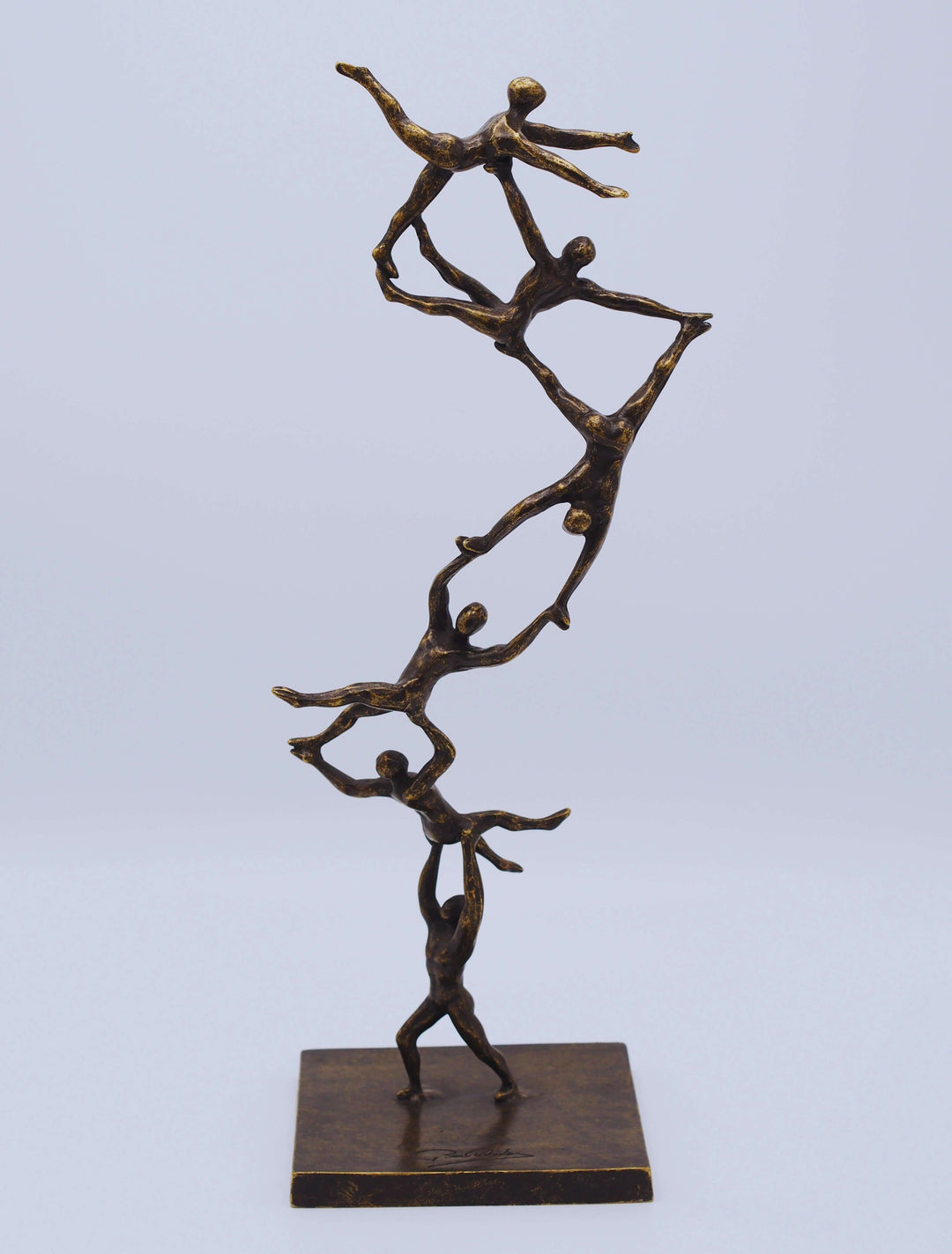 Bronze sculpture 'Together to the Top' depicting abstract figures in a dynamic teamwork climb, symbolizing ambition.