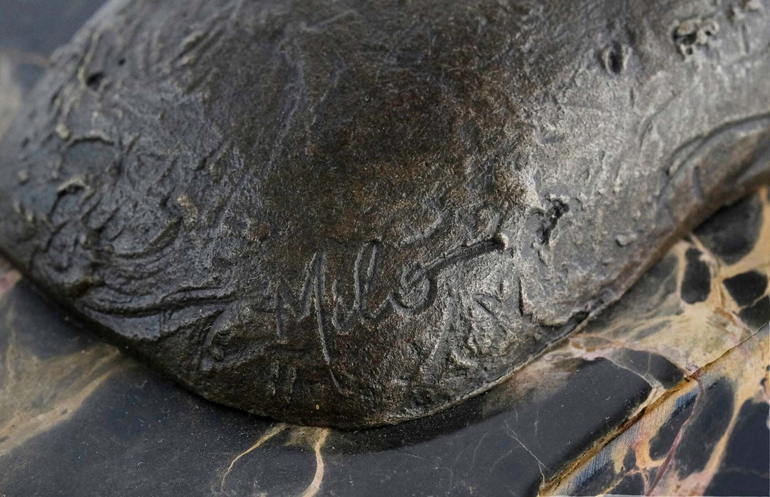 Close-up of Milo's signature on a bronze sculpture, showcasing fine details and quality craftsmanship.