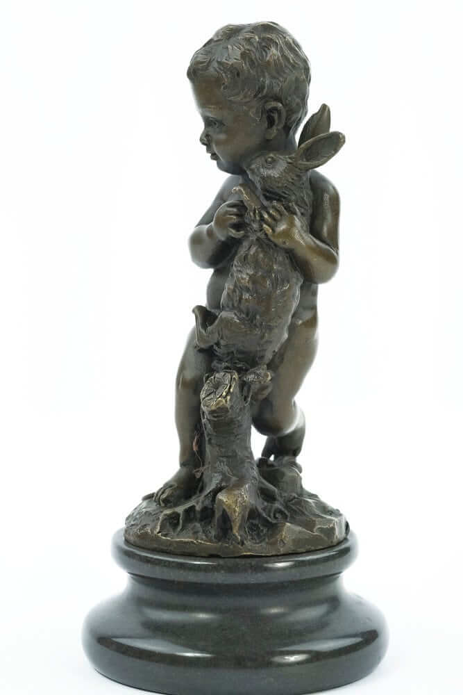Bronze sculpture of a young boy lovingly holding a rabbit, mounted on a round marble base.