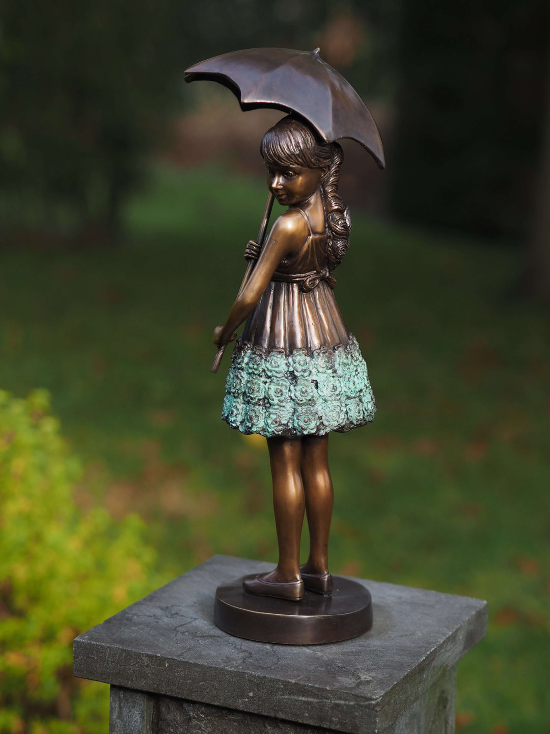 Bronze sculpture of a young girl with an umbrella, elegantly dressed, ideal for indoor or outdoor display.