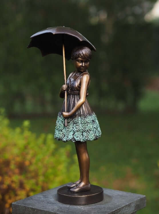 Bronze sculpture of a young girl holding an umbrella, elegantly dressed, multi-colored patina finish.