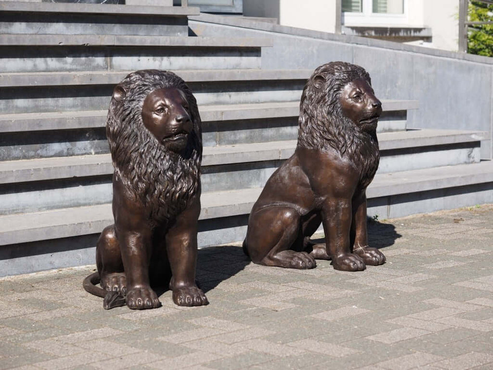 Elegant bronze sitting lion sculptures, symbolizing dignity and protection, perfect for any outdoor entrance.