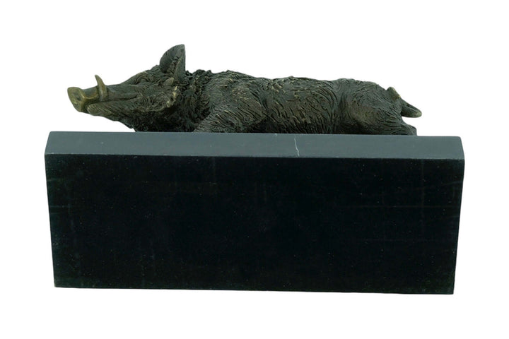 Bronze wild boar sculpture resting on a black marble base, showcasing fine details and warm patina.