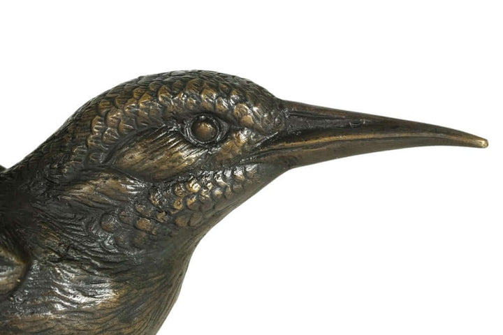 Close-up of a detailed bronze kingfisher sculpture showcasing lifelike features and intricate texture.
