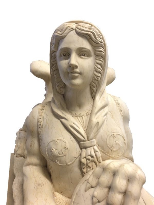 Close-up of a detailed marble sculpture of a woman with intricate features and draped attire.