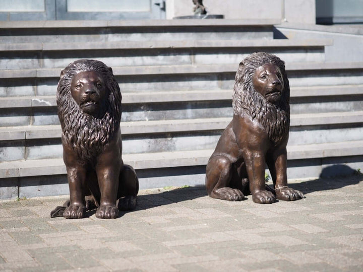 Pair of bronze sitting lion sculptures, elegant guardians for entrance, driveway or garden.