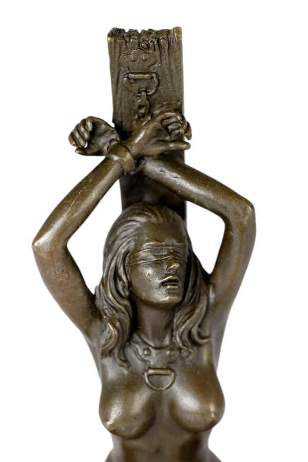Erotic bronze sculpture of a blindfolded female chained to a wooden pole, showcasing fine craftsmanship and warm patina.