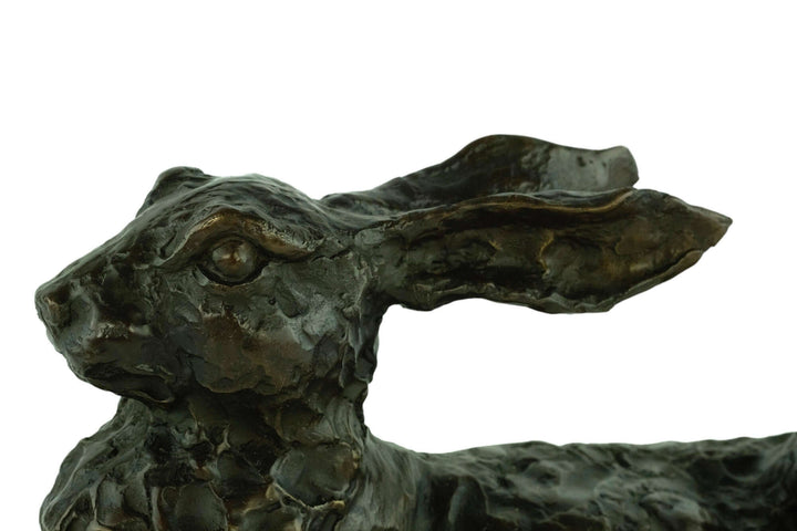 Close-up of a large bronze reclining hare sculpture showcasing intricate detail and warm patina finish.