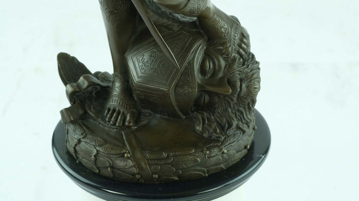 Large bronze sculpture of David triumphantly standing on Goliath's head, showcasing intricate details.