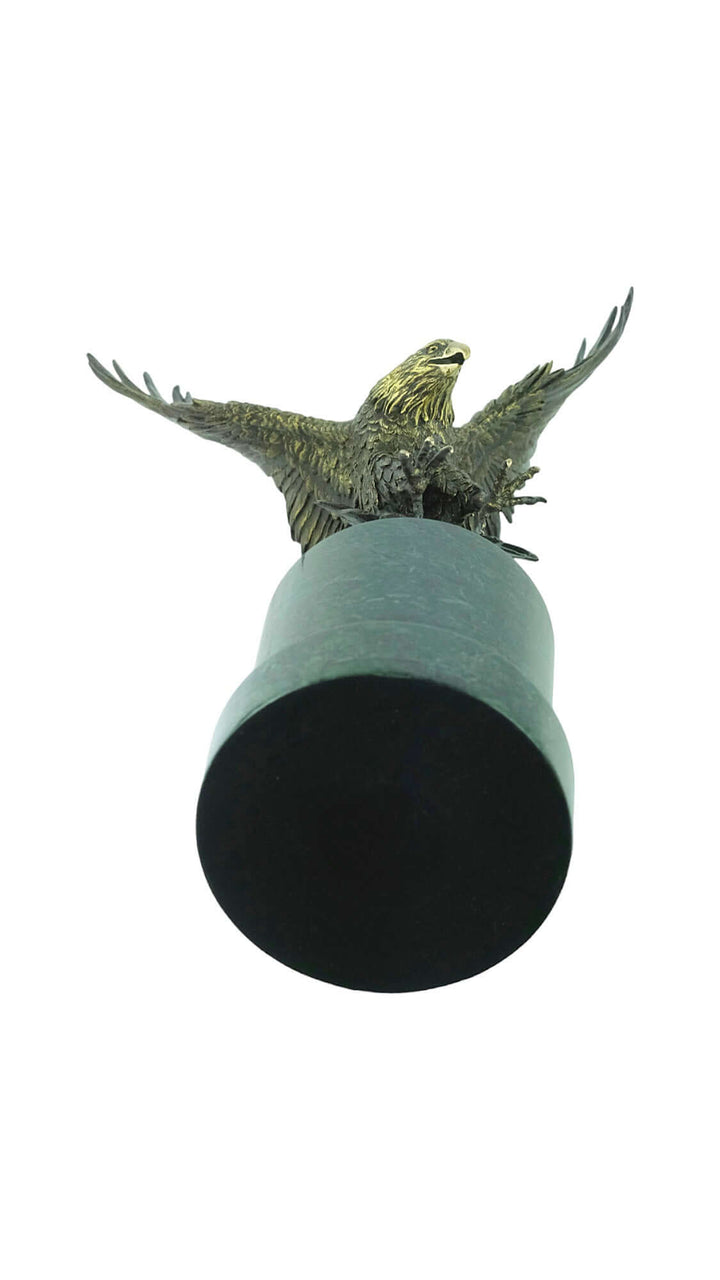 Large bronze fishing eagle sculpture with open wings mounted on a black marble column, exuding elegance.