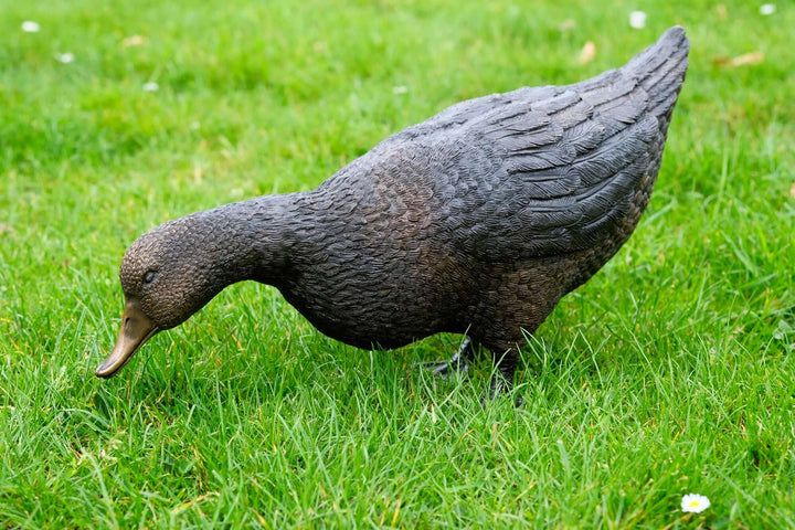 Lifesize bronze sculpture of a foraging duck, detailed design for garden or outdoor display.