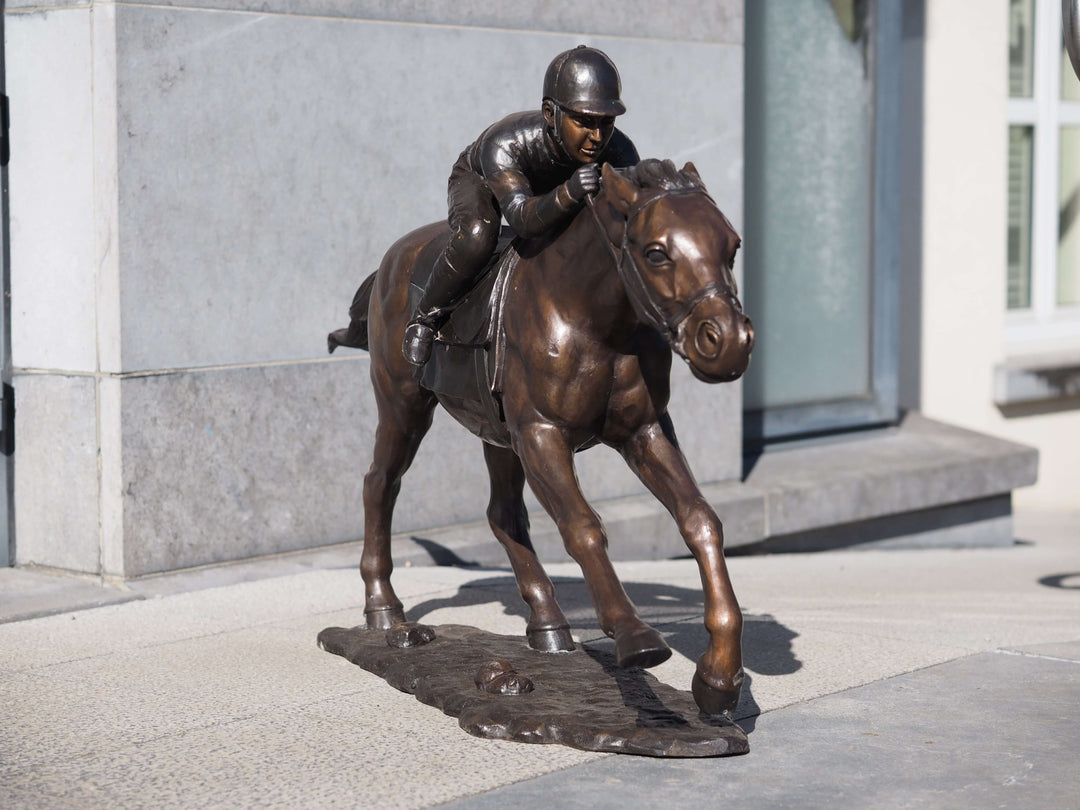 Large bronze sculpture of a jockey racing a horse, showcasing detailed movement and determination, perfect for outdoor display.