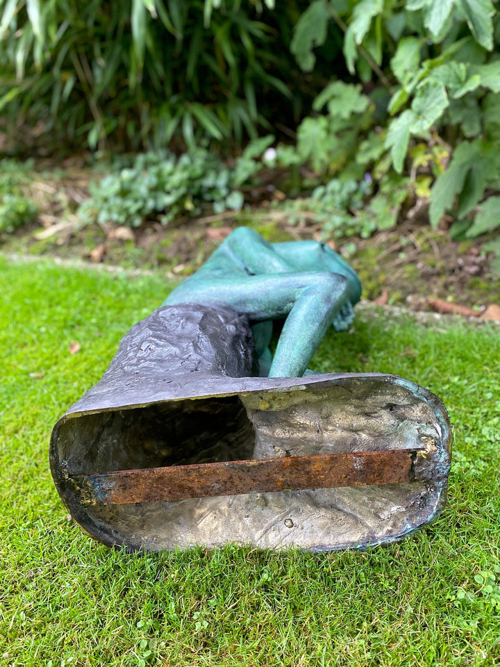 Large bronze sculpture of a thinking frog, showcasing its serene expression and multi-coloured patina outdoors.