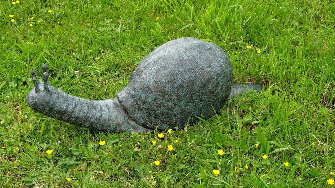 Large bronze snail sculpture and fountain in grass, perfect for enhancing garden charm and character.