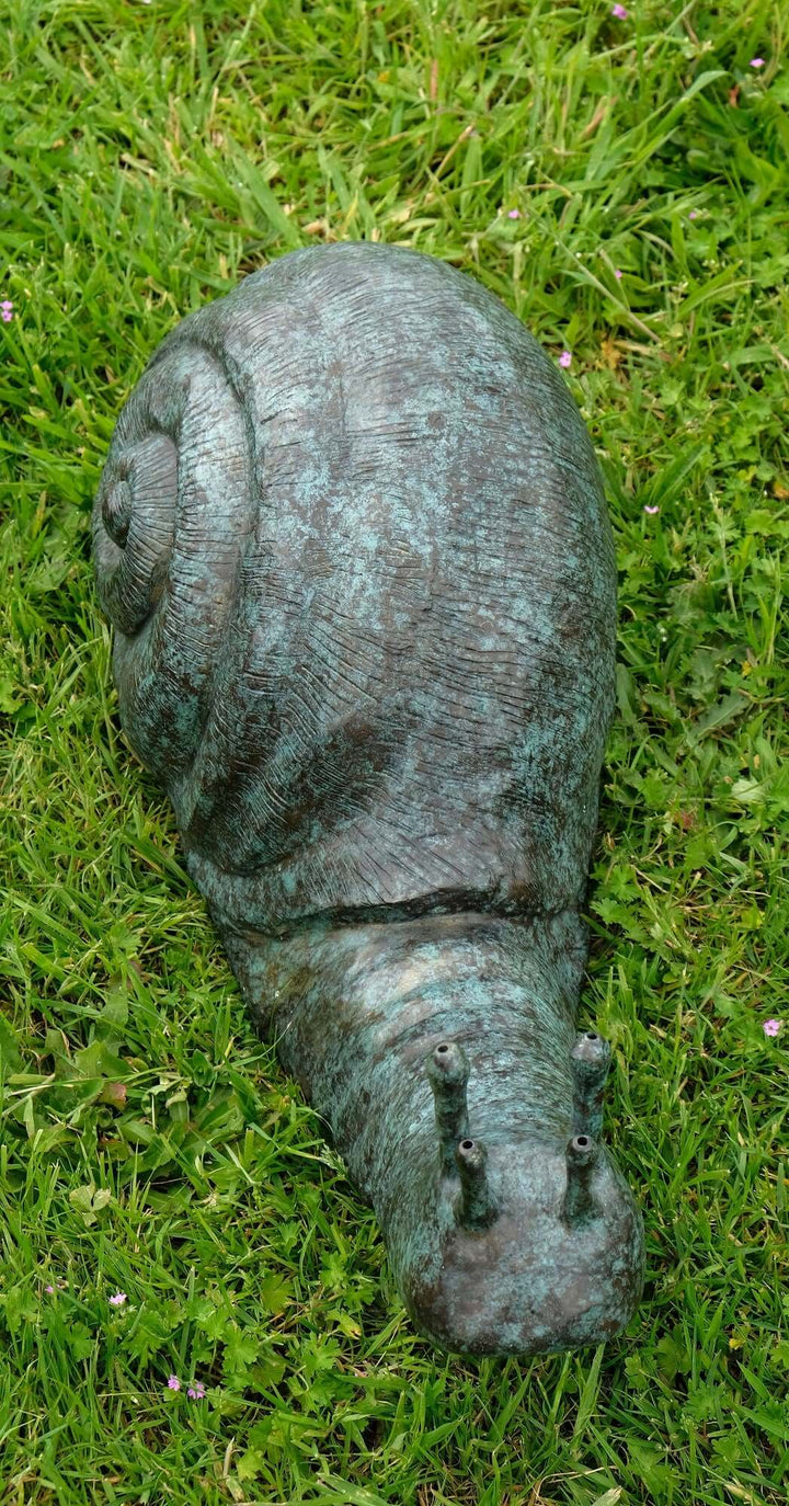 Large bronze snail sculpture with mottled green patina on grass, ideal for garden decor and fountains.
