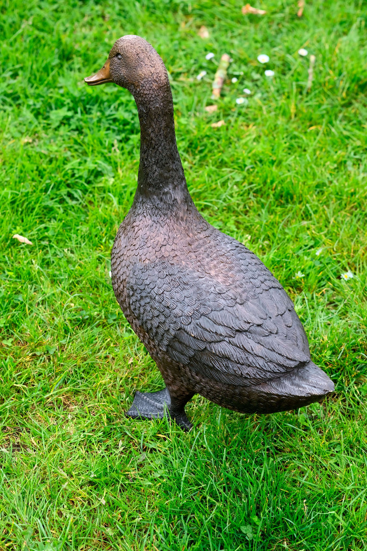 Lifesize bronze duck sculpture in a natural standing pose on grass, detailed and suitable for outdoor display.