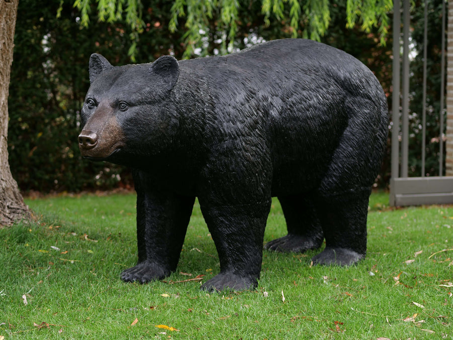 Lifesize bronze sculpture of a black bear in an outdoor setting, showcasing intricate detail and robust design.