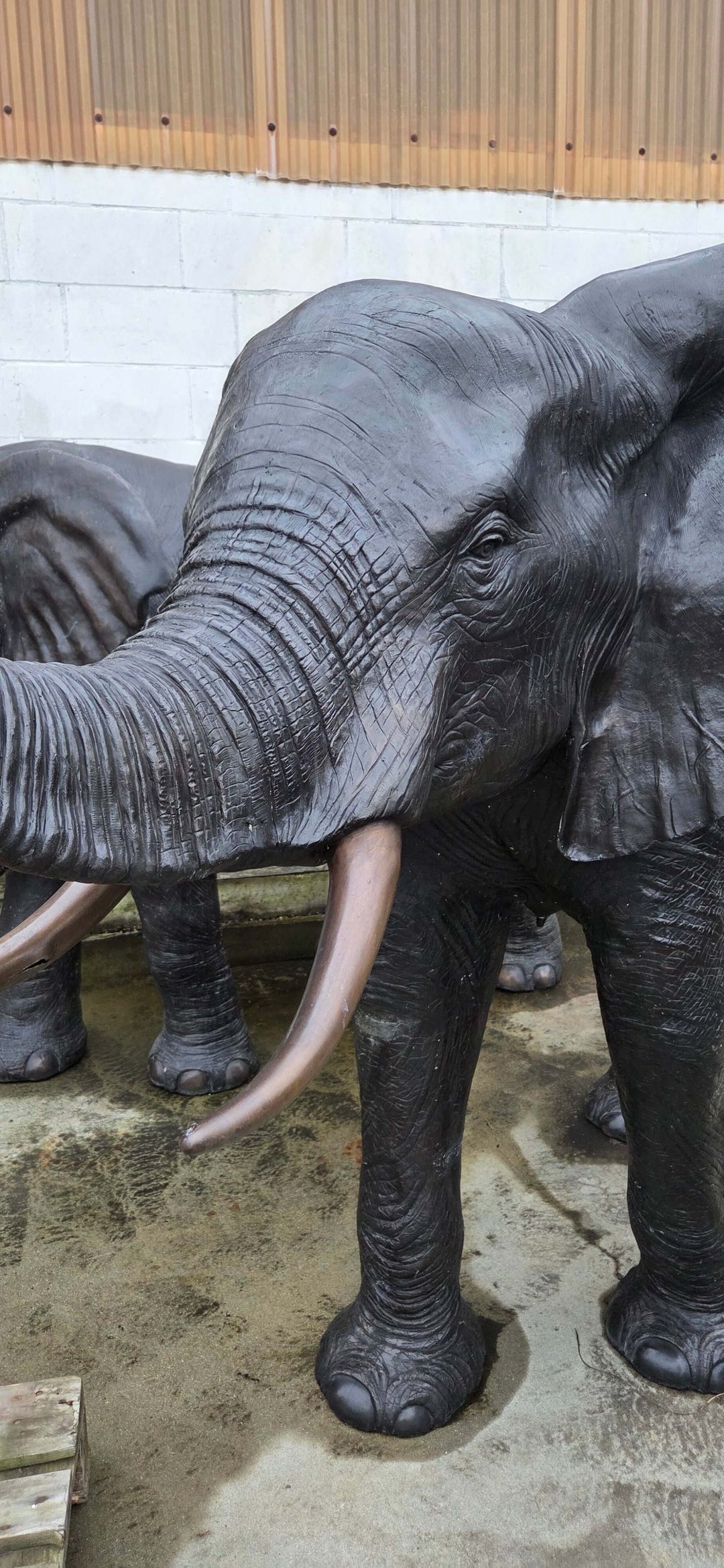 Lifesize bronze elephant sculpture with trunk raised, showcasing detailed features and elegant design.