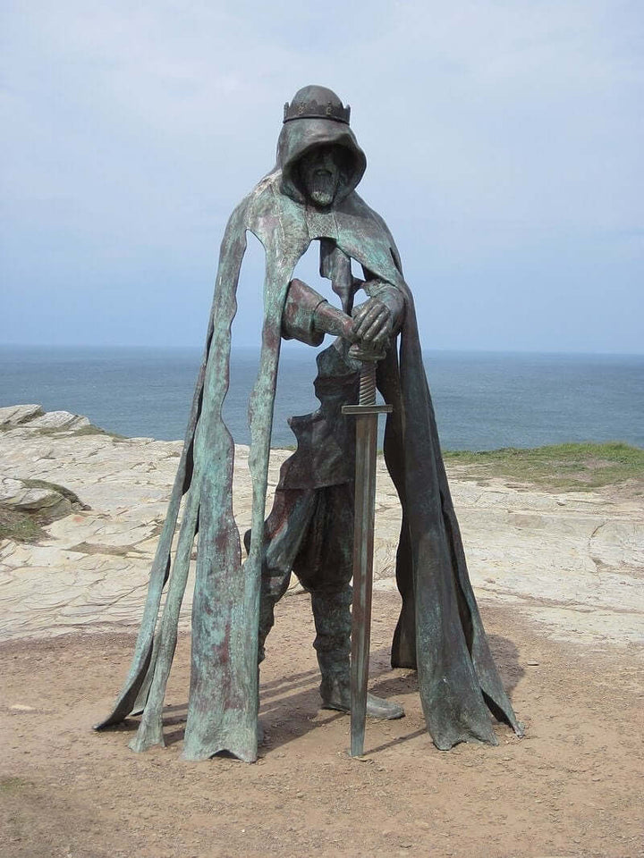 Lifesize bronze sculpture of King Arthur with sword overlooking the sea at Tintagel Castle, Cornwall.
