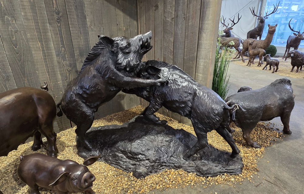 Lifesize bronze sculpture of two wild boars fighting, perfect for outdoor decor, showcasing craftsmanship and nature.