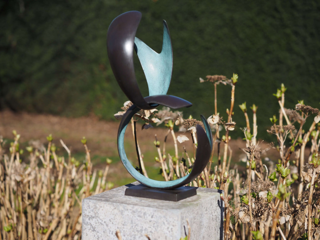 Modern bronze sculpture representing unity with abstract forms and a green patina, ideal for artistic displays.