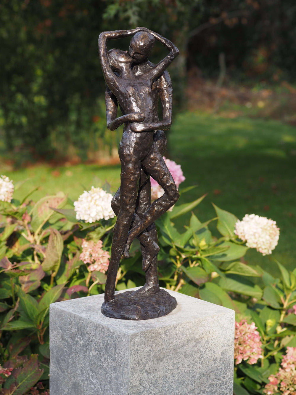 Modern bronze sculpture of a loving couple sharing a kiss, perfect for indoor or outdoor display.