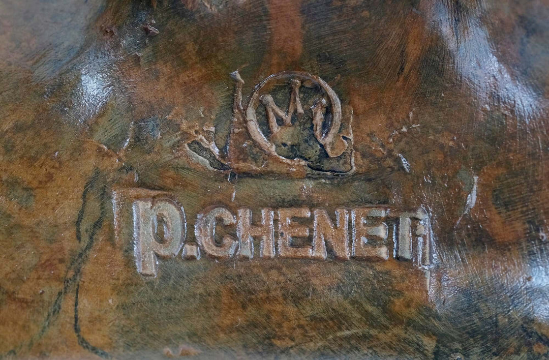 Close-up of P. Chenet signature and foundry stamp on bronze sculpture, showcasing quality craftsmanship.