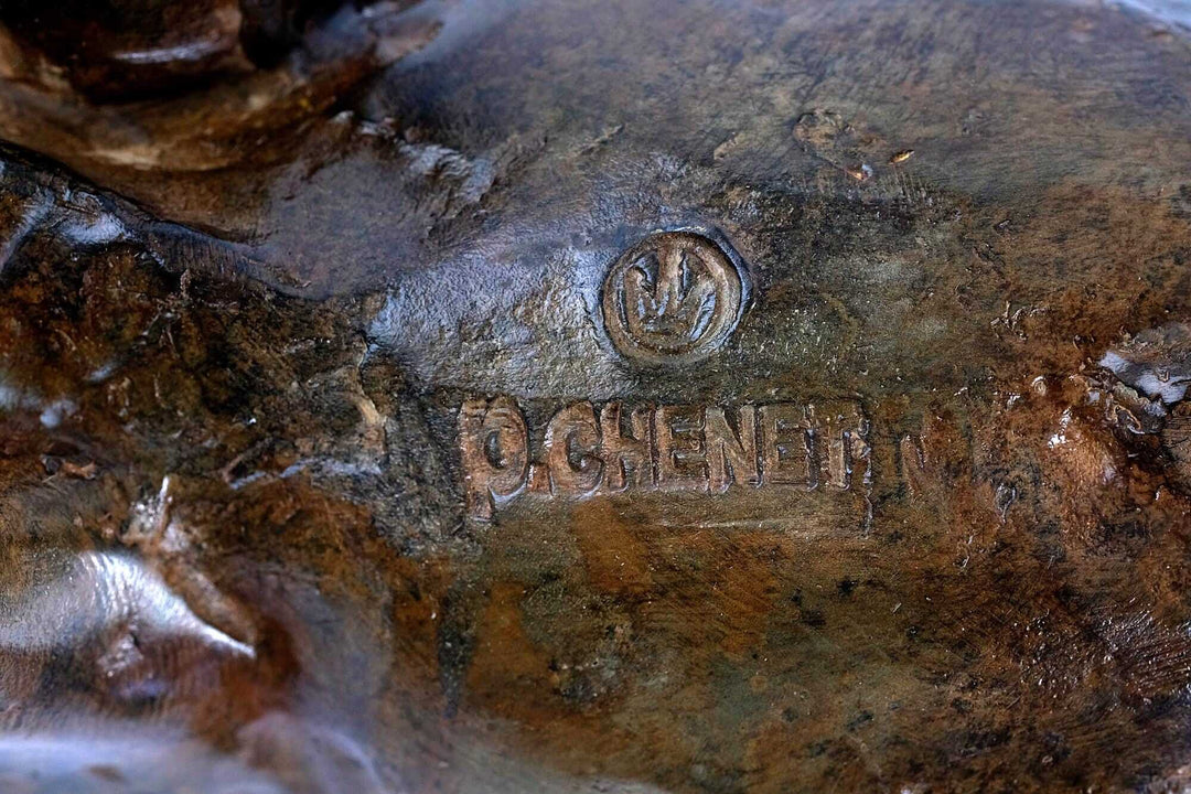 Signature and foundry stamp on a bronze charging bull sculpture by Pierre Chenet, showcasing craftsmanship.